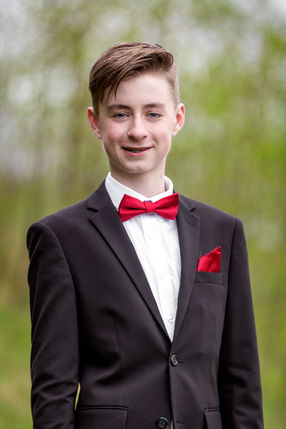 Konfirmationsfotografering portræt at ung dreng med rød butterfly