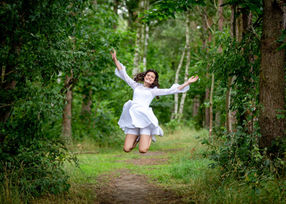 Konfirmationsfotografering af pige hoppende gladeligt