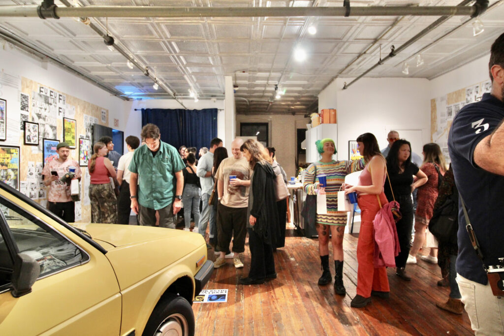 A crowd of gallery goers stands around the VW Golf in the Blue Triangle Gallery. Photo courtesy by Harmony Witte
