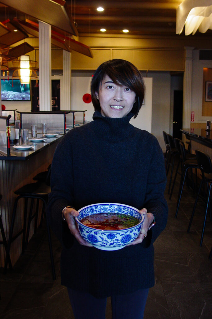 Peng Jia of Lan Feast displays her restaurant's signature beef noodle dish.