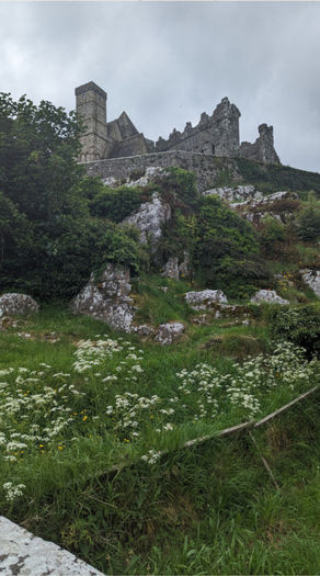 Photography of old Ireland castle taken from bottom of cliff/hill.
