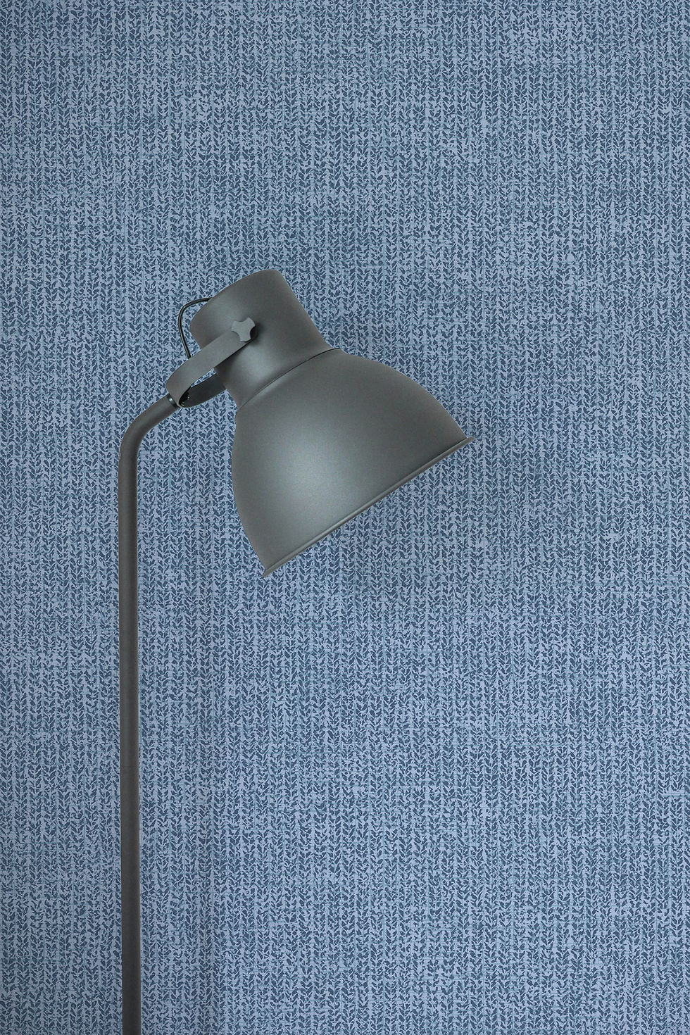 Lamp against blue tweed-inspired wallcovering.