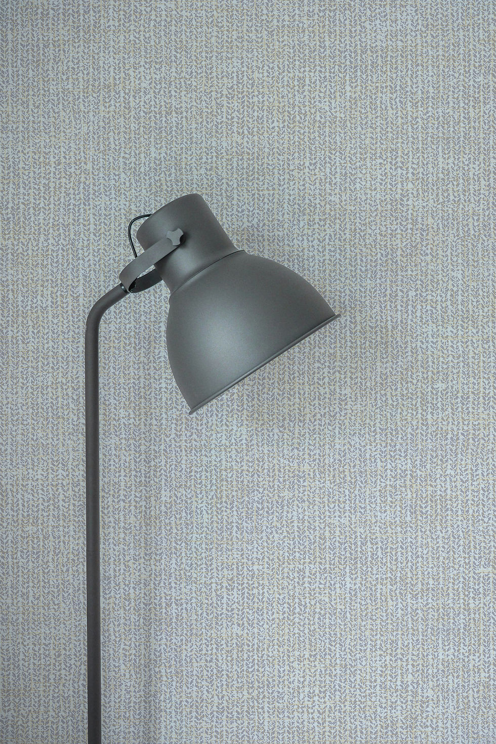 Lamp against blue grey tweed-inspired wallcovering.