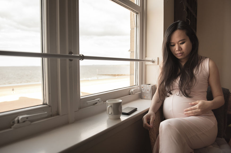 Pregnant Woman holding baby bump with coffee getting advice on pregnancy nutrition