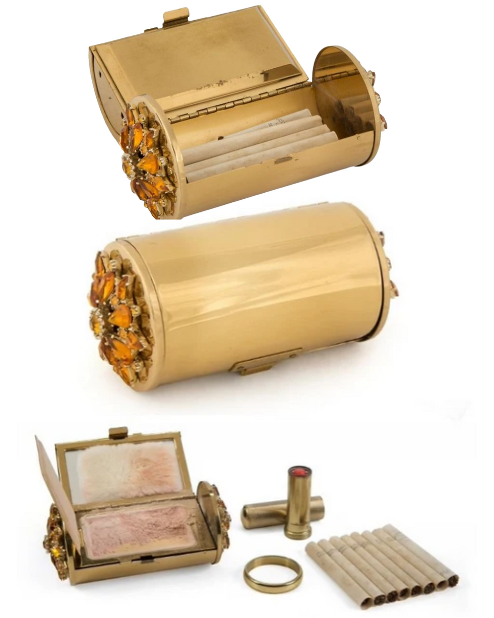 Marilyn Monroe's minaudière compact containing eight Philip Morris cigarettes, a tube of lipstick, a clear plastic comb and loose powder.