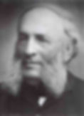 Elderly man with thick sideburns, wearing a dark suit, looks content. Black and white portrait with a neutral background.