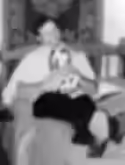 A man sat on a bed holding a soft toy