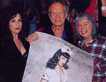William S. Burroughs holds pin-up nurse poster, flanked by two women.