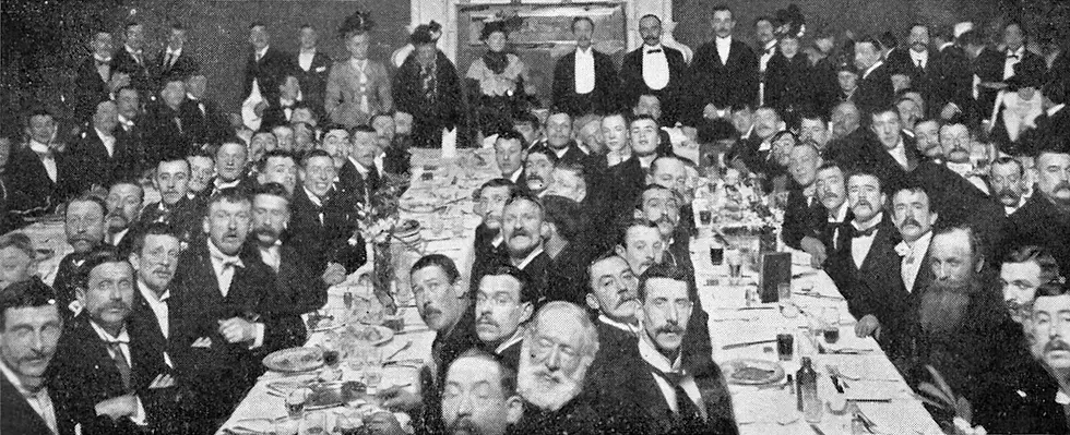 Photograph of cat’s meat men attending their supper, 1901. Louis Wain stands at centre back next to Frances A. Simpson, a notable fancier and cat historian