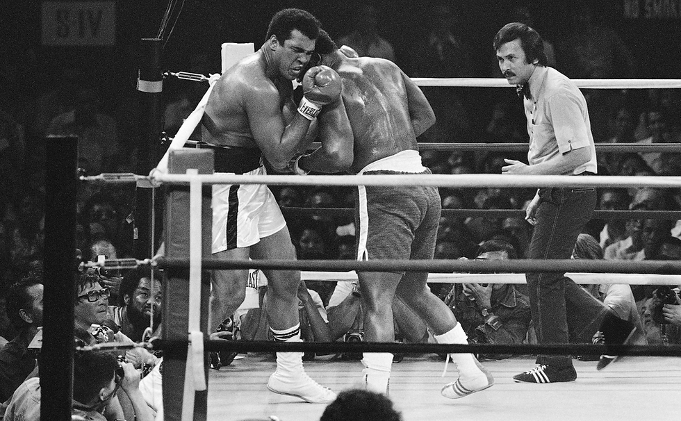 Muhammad Ali grimaces as he exchanges blows with Joe Frazier in the early rounds in Manila.