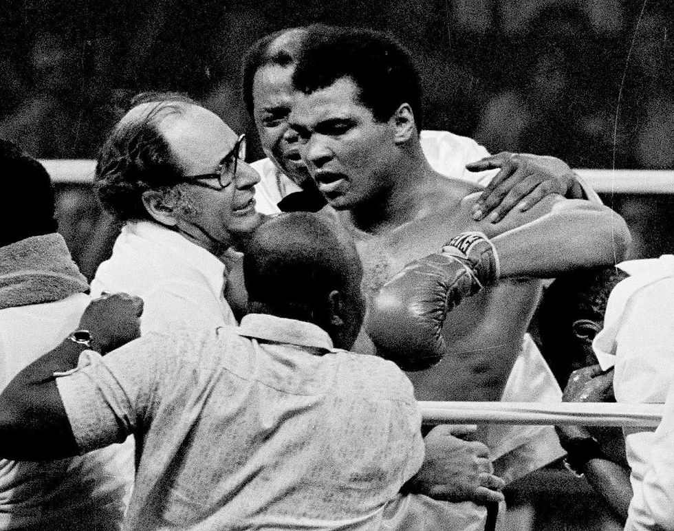 Muhammad Ali, still the heavyweight champion of the world, is surrounded by fight fans as he is led to his dressing room after retaining his crown by 14th round