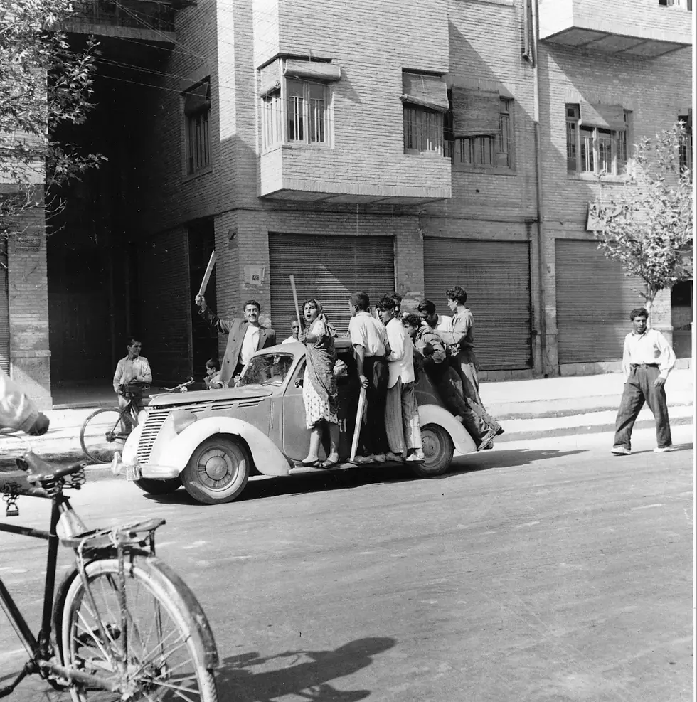 An Iranian woman waves a club after joining other demonstrators in the streets of Tehran. British and U.S. intelligence agencies helped organize protests and pull pro-Shah forces together.