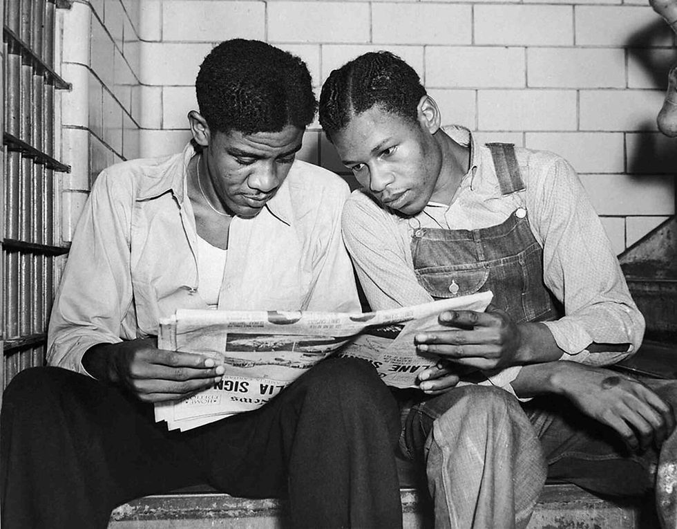 July 16, 1937 file photo, Charlie Weems, left, and Clarence Norris, Scottsboro case defendants, read a newspaper in their Decatur, Ala. jail after Norris was found guilty for a third time by a jury which specified the death penalty.