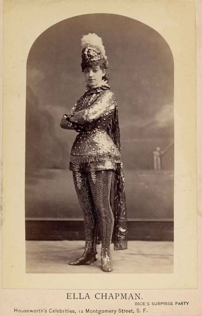 Woman in a short metallic armour costume, including leggings, helmet with feather.