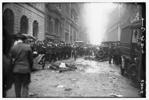 Wall Street Bombing of 1920 aftermath: bodies, debris, damaged car, and onlookers.