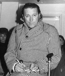 Gene Vincent in a houndstooth coat with a walking stick, signing autographs, in what's said to be his last photo