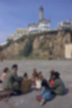 Diverse group sitting outdoors on Alcatraz Island with white buildings. Urban Spaces.