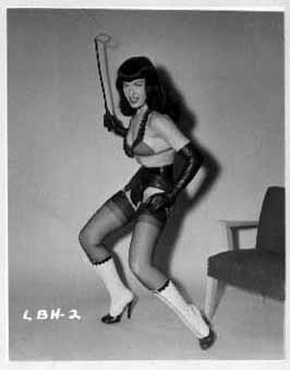 Bettie Page playfully poses with whip in lingerie and boots. LBH-2.