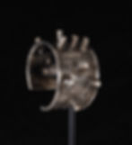 Intricately engraved silver cuff bracelet with protruding spikes on a black background, showcasing detailed patterns and metallic shine.