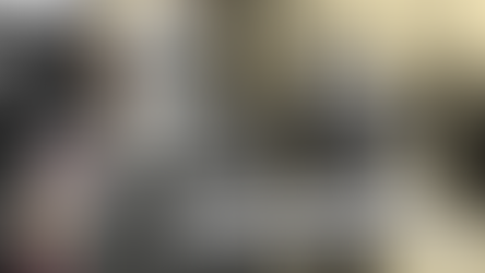 Bearded man in suit with an orchid, smiling. He stands on a busy street with vintage cars. Text reads: "Nubar Gulbenkian: The Orchid Wearing Playboy Millionaire."