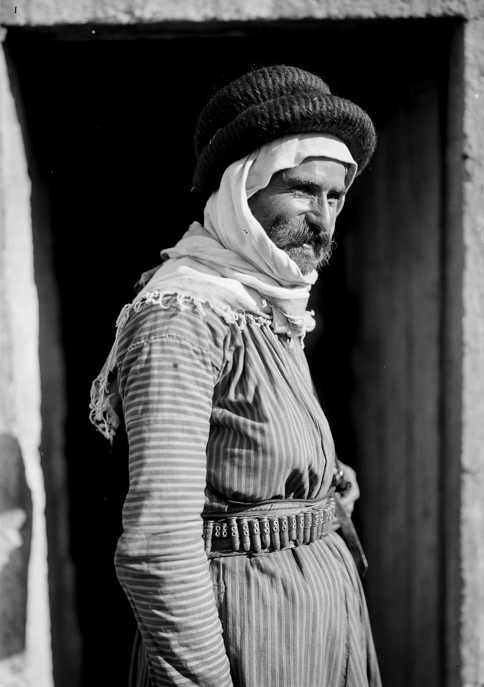 A side profile image of a man in tradition desert robes