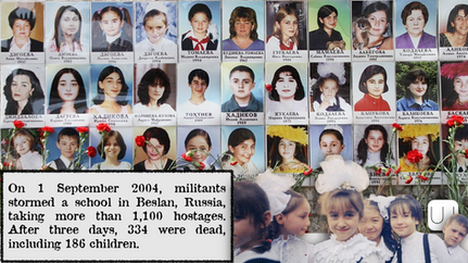 Photos of children and adults are displayed with red flowers below, commemorating the 2004 Beslan school siege victims. somber mood.