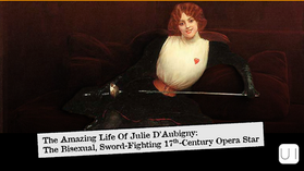 Woman with a sword reclines on a dark red sofa, wearing a white blouse and black gloves. Text reads: "The Amazing Life Of Julie D’Aubigny."
