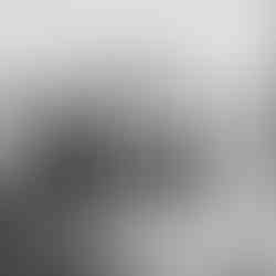 Black-and-white photograph of a group of Bedouin men engaged in a playful activity where some are carrying others piggyback-style in a row, creating a chain-like formation. They stand on a sunlit desert plain with mountains in the background. Taken in the early 20th century by the American Colony Photo Department.