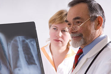A doctor and a nurse reviewing an x-ray image of a human lung