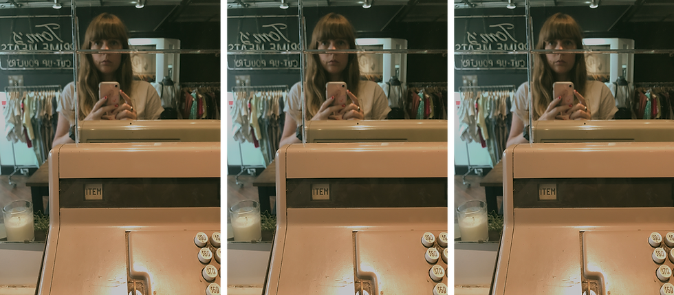 A woman taking a selfie in a clothing store with a vintage cash register in the foreground