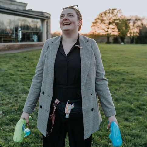 Molly holding bubble guns in her hands watching the sky at golden hour