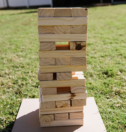 Picture of a giant wooden Jenga game displayed on a lawn.