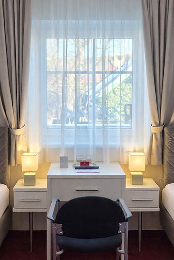 Komfortables Doppelzimmer Twin Basic im Hotel Kramer in Villach mit zwei getrennten Betten und heller Bettwäsche.
