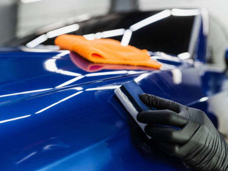 Installer working on a deep blue paint finish