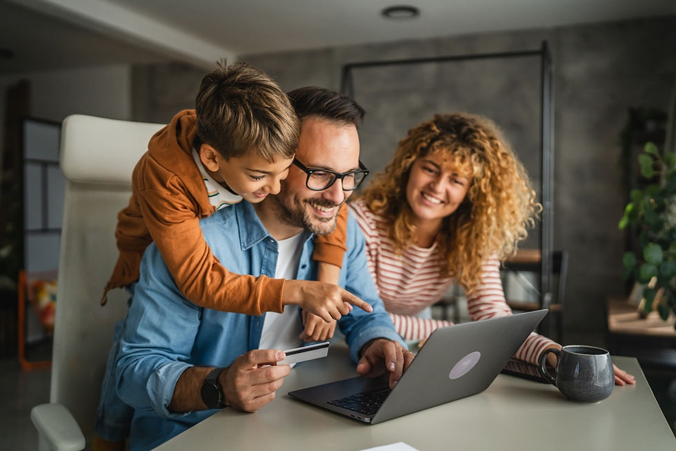 Family looking at a laptop together while holding a card