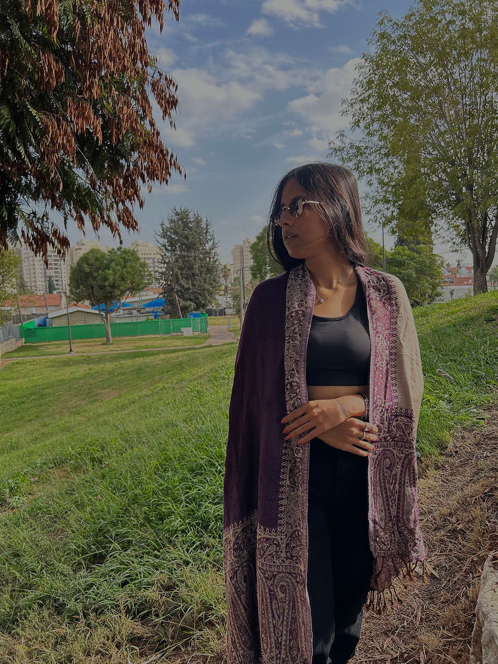 אישה צעירה מסתכלת הצידה עם תיק צד אלכסון מבד | מיין באזר 10 על רקע פארק ירוק.