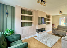 Finished Hassocks media wall viewed from the right, showing illuminated display shelves and slat panelling either side of the fire
