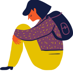 A person wearing a backpack sitting and hugging their knees.