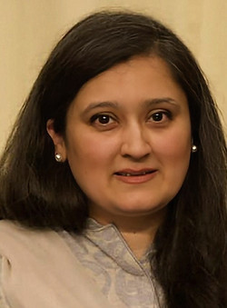 Headshot of Zubda Zia Ur Rehman wearing a brown top and pearl earrings.
