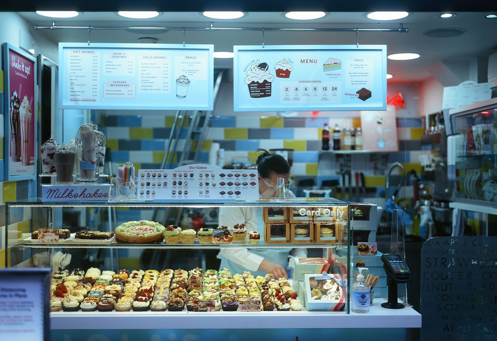 A colour photograph of a server in a Lola's Cupcakes shop in Covent Garden, London.
