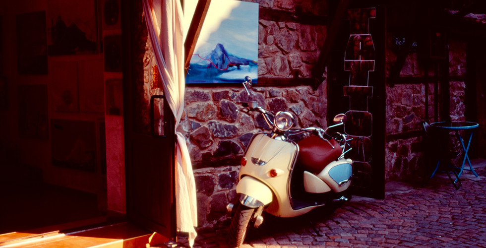 Sunny photograph of a moped.