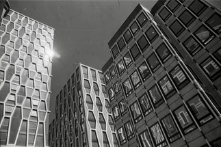 Black and white photograph of office blocks in Victoria, London, viewed from below