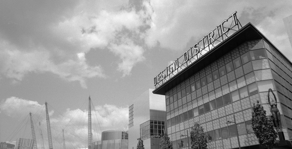 Black and white shot of the Millenium Dome alongside the new Design District area in North Greenwich