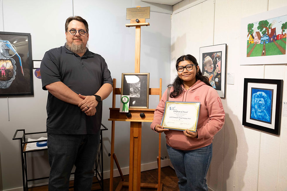 Lourdes stands with her photograph Moth on Banana, a study of light, detail, and the quiet beauty found in everyday subjects.