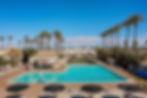 Wide angle view of the Palm Creek RV Resort swimming pool surrounded by palm trees