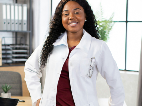 African American nurse leaning against a desk