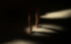 a woman walking in dark with leaks of sunlight on her feet