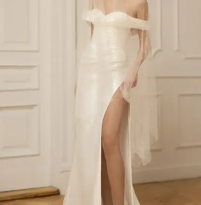 Bride wearing the Eva Lendel Lea off-the-shoulder Mikado wedding dress with slit and overskirt.