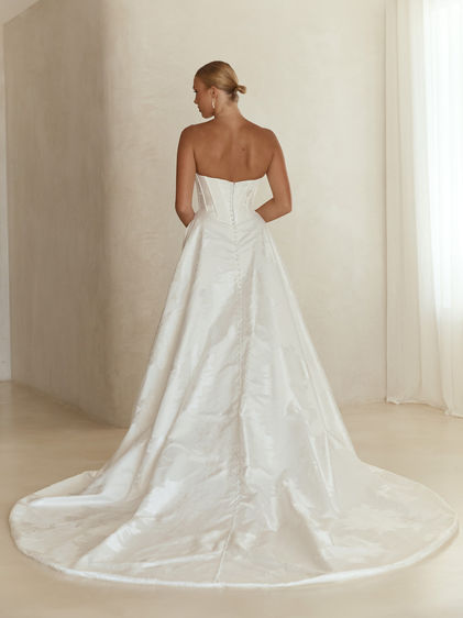 Back view of Tuscan by Serene wedding dress with button detailing and long train