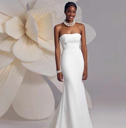 Bride wearing the Eva Lendel Amalfi fitted crepe wedding dress with asymmetric neckline and detachable floral feather belt at Elizabeth Kate Bridal.